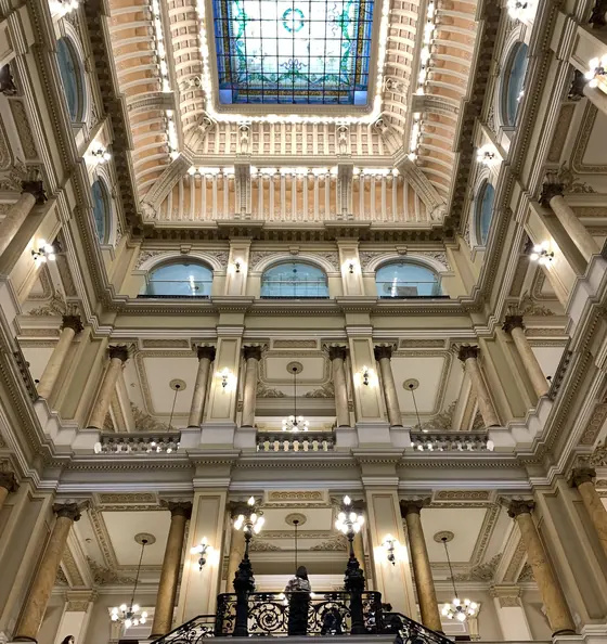 Interior de um museu no Rio de Janeiro, com colunas, escadaria e vitral no teto