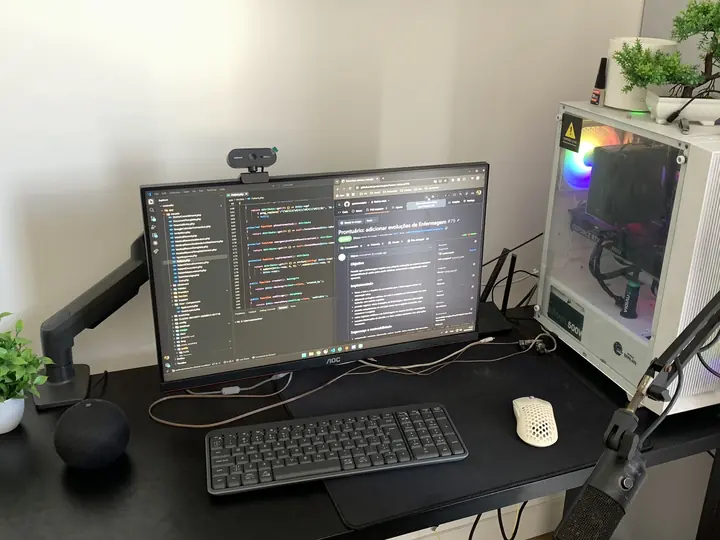 Mesa de trabalho do Gustavo, com o monitor mostrando código