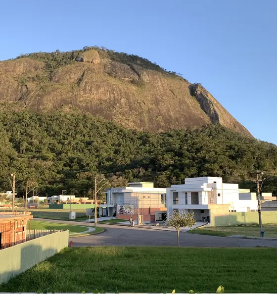 Montanha de pedra ao fim da tarde, com casas na frente